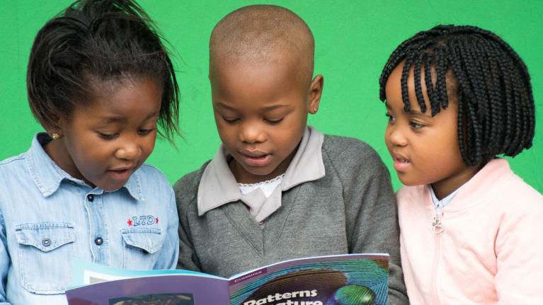 South African primary school students reading a Cambridge course book.