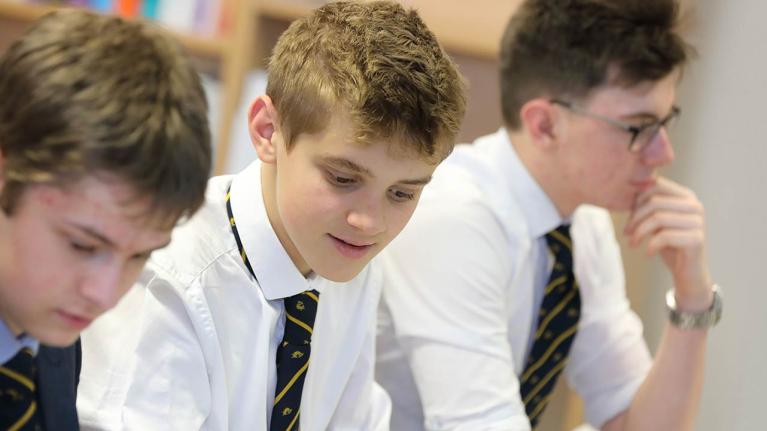 UK secondary school students working in classroom.