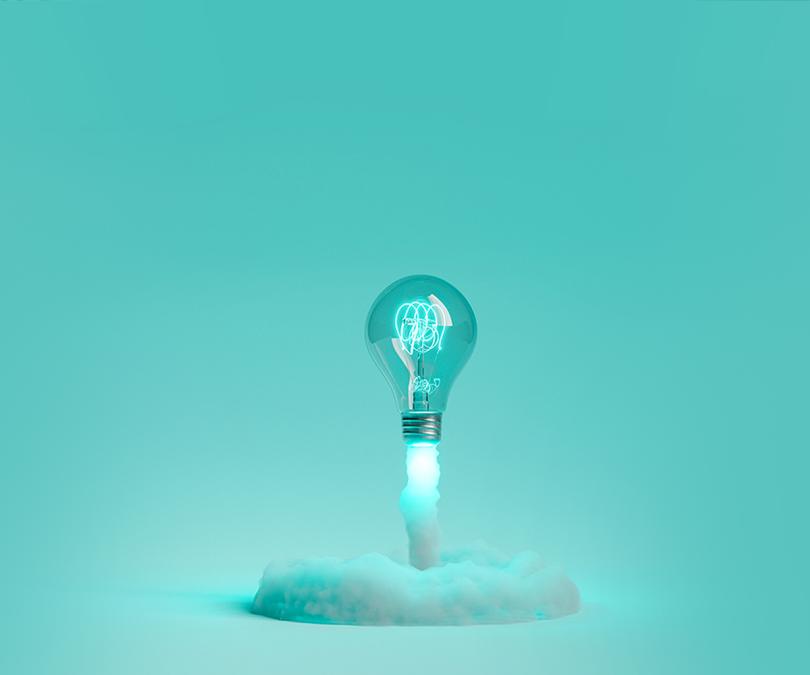 Lightbulb launching and releasing smoke on a blue background